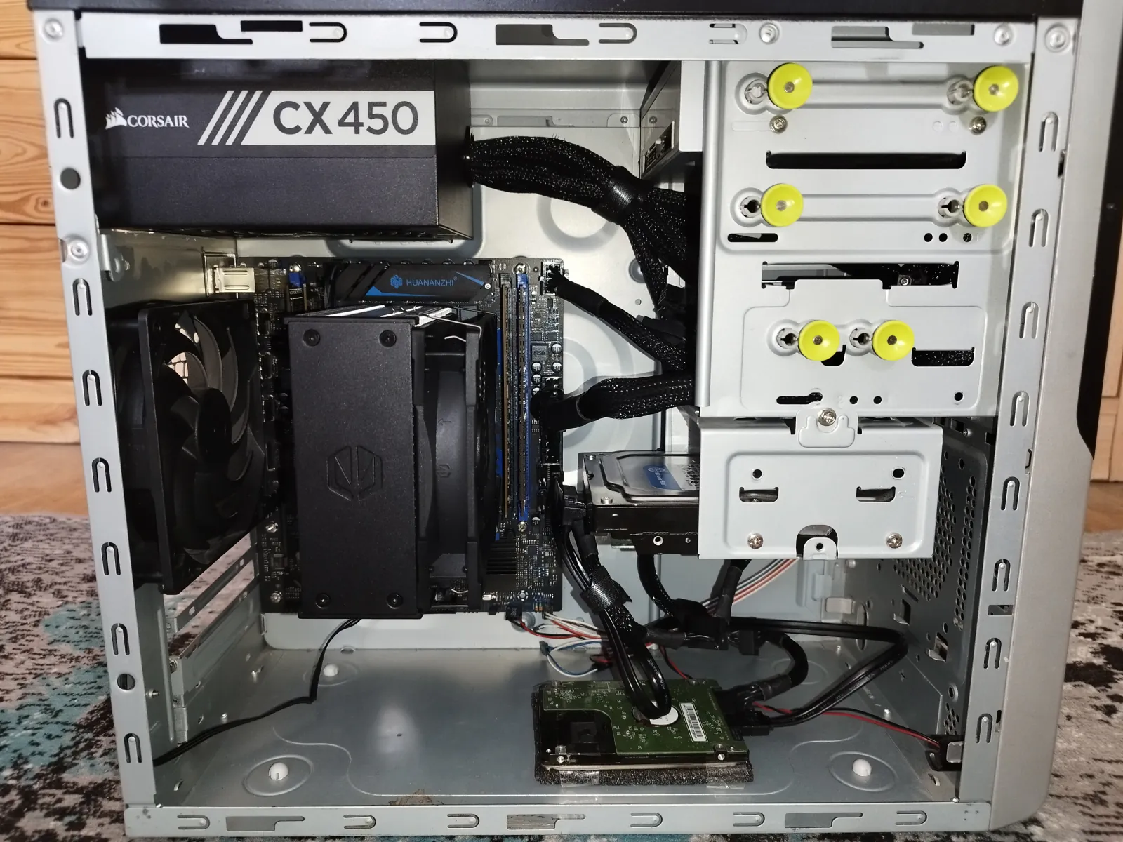 The Proxmox server with the side panel off: Corsair CX450 PSU, Huananzhi board with an Endorfy Fera 5 cooler, RAM and WD drives in a reused office case.